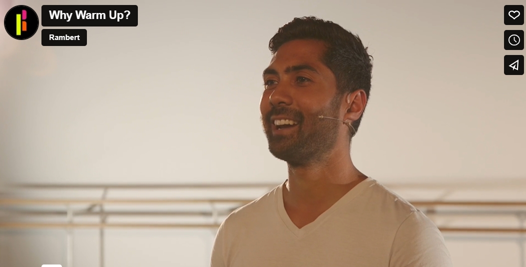 A man in a white shirt is smiling in front of a mirror.