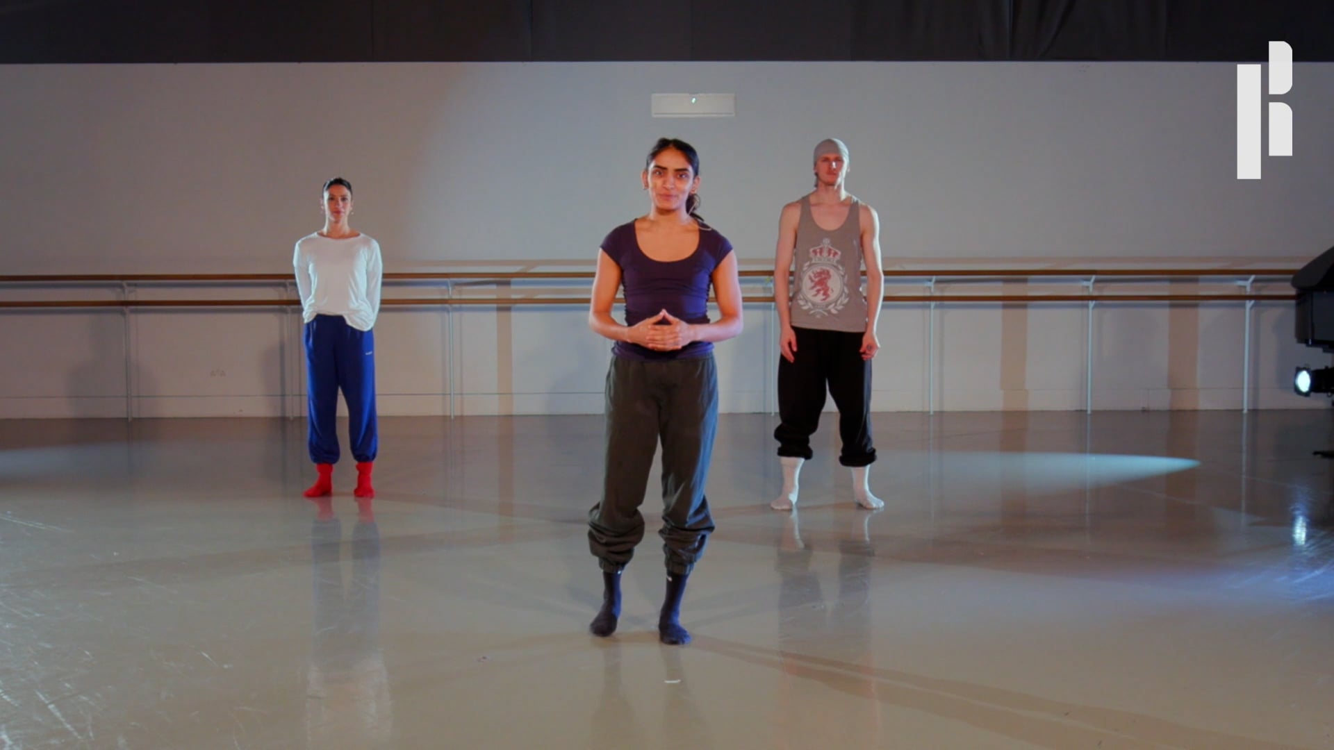 A group of people standing in a dance studio.
