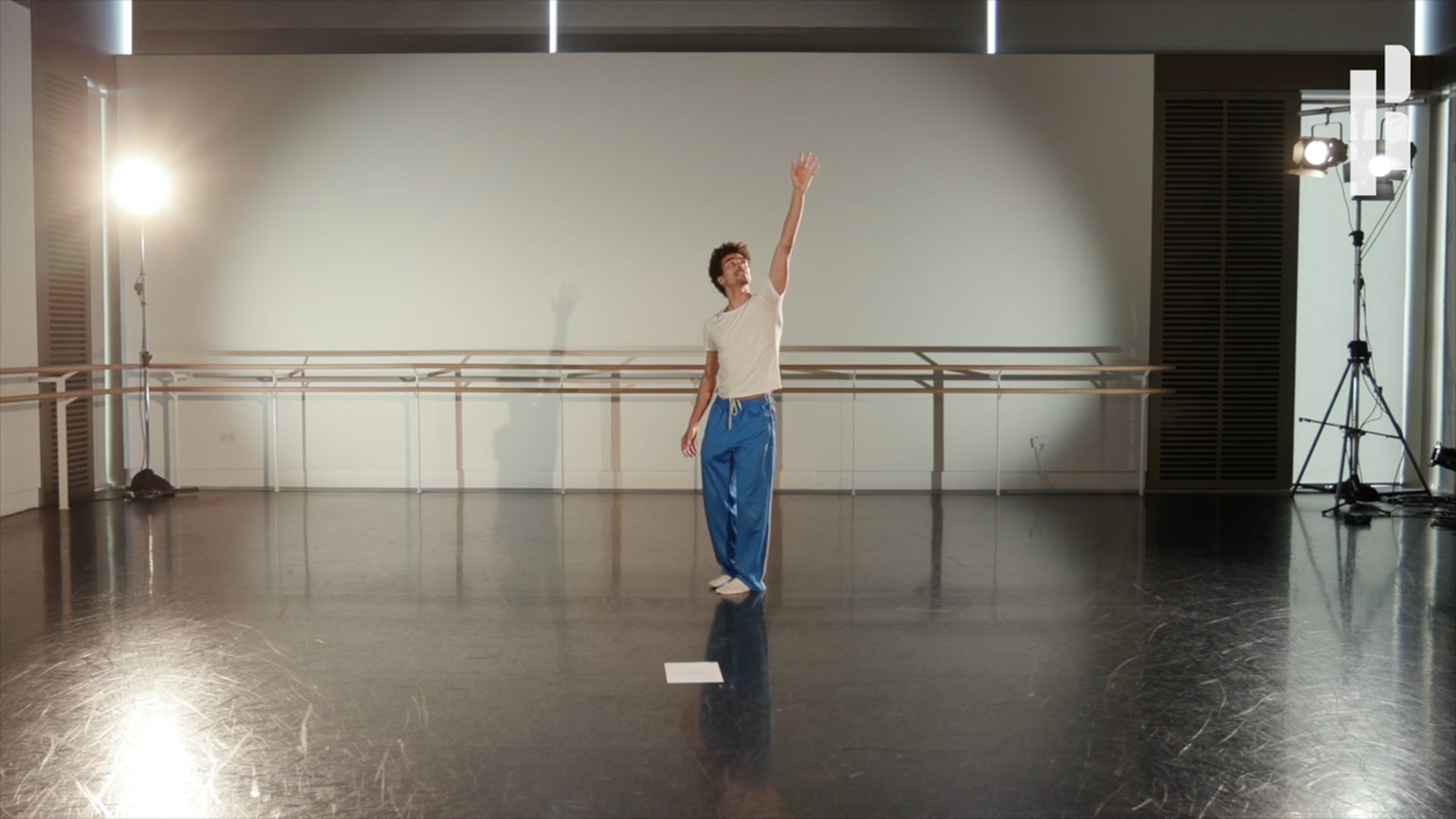 A dancer in a studio with a camera in front of him.