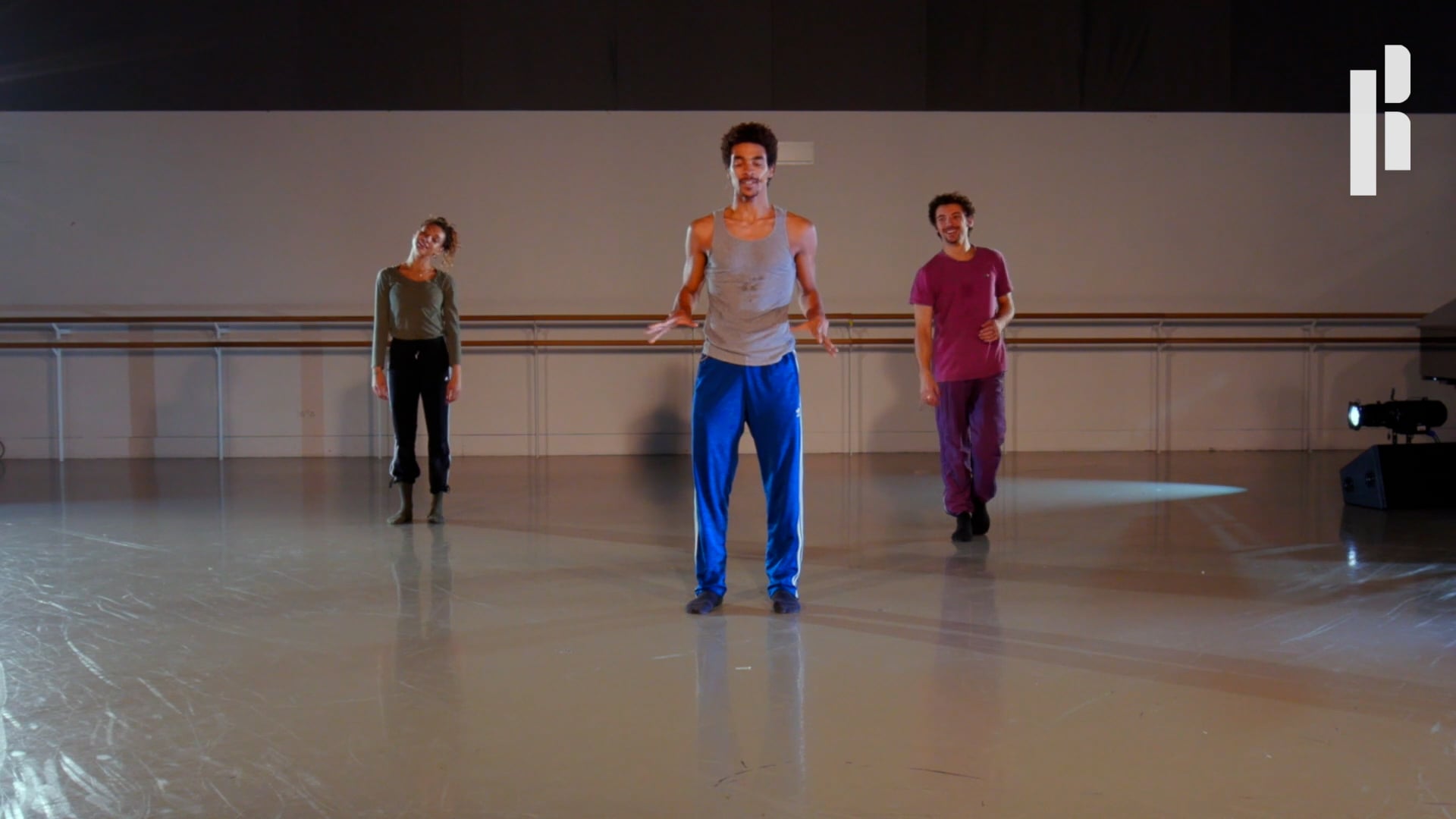 A group of people standing in a dance studio.