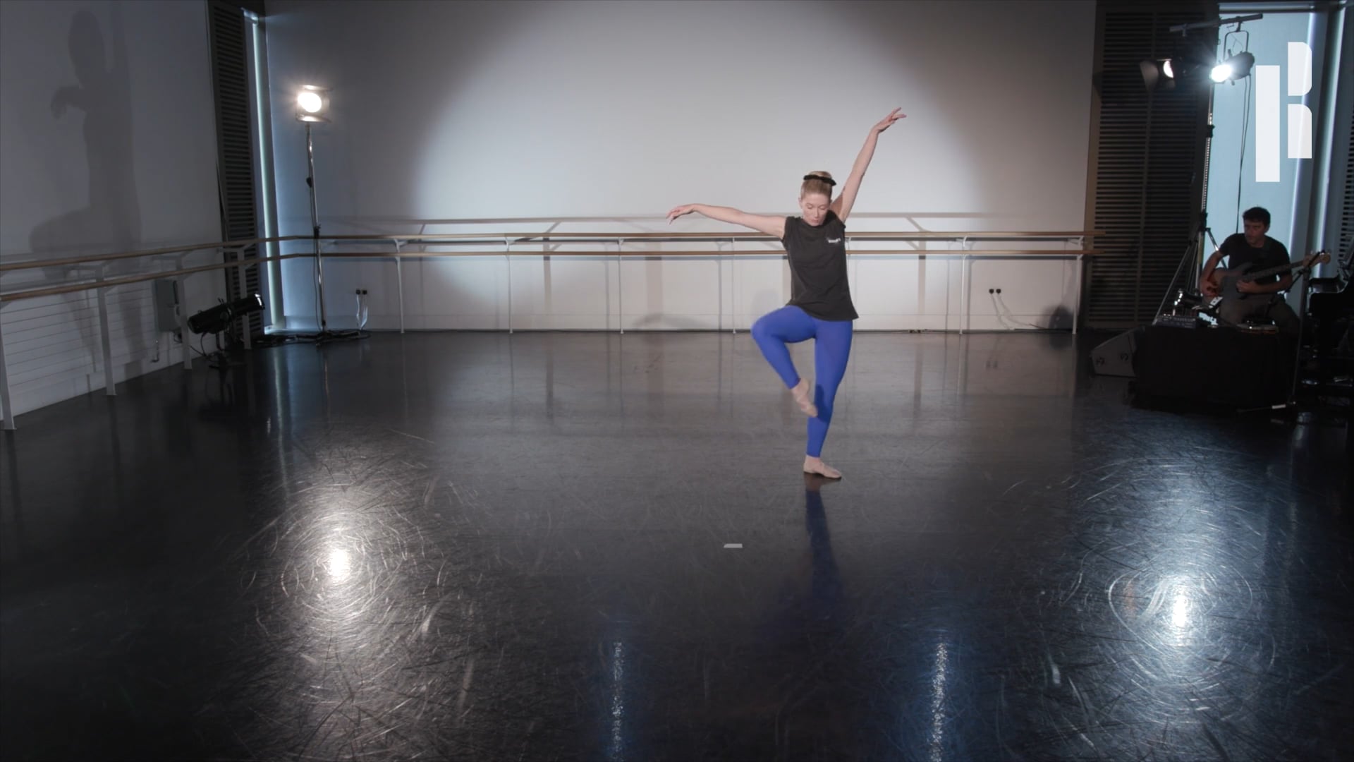 A woman is dancing in an empty dance studio.
