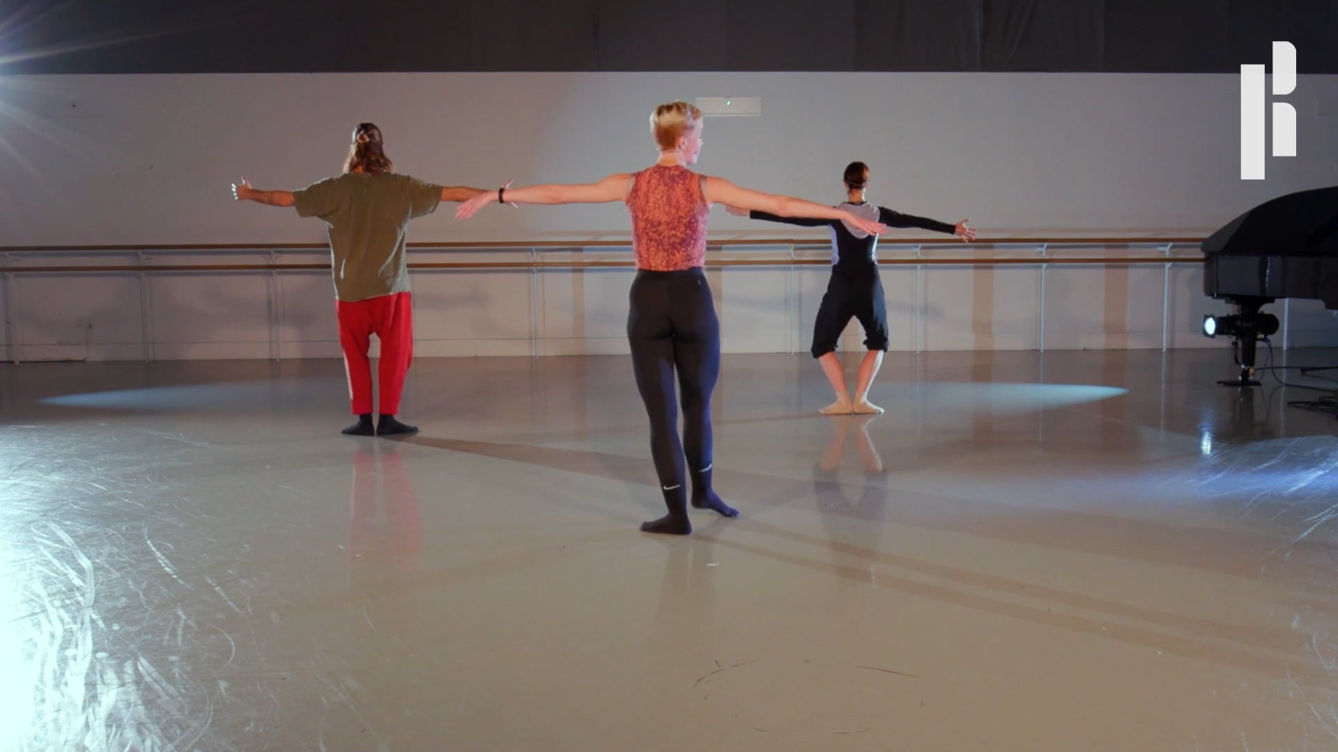 A group of dancers in a room with a piano.
