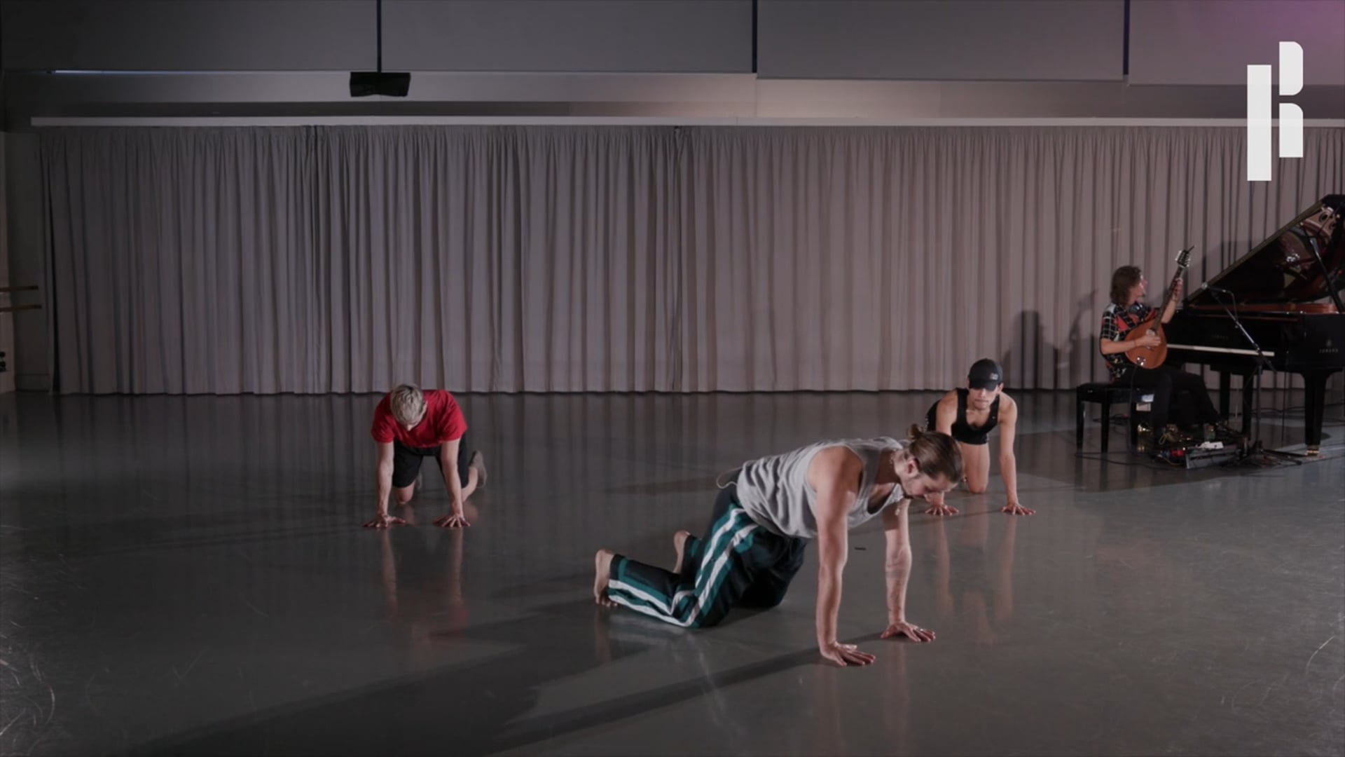 A group of dancers in a room with a piano.