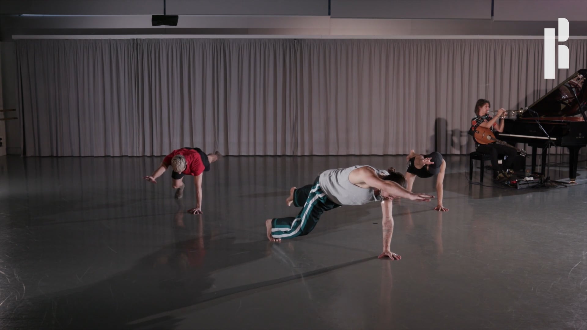 A group of dancers in a room with a piano.