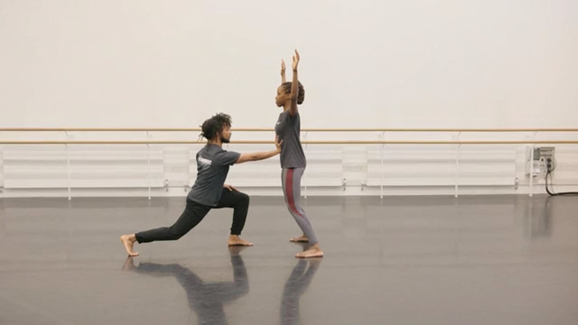 Two dancers practicing in a dance studio.