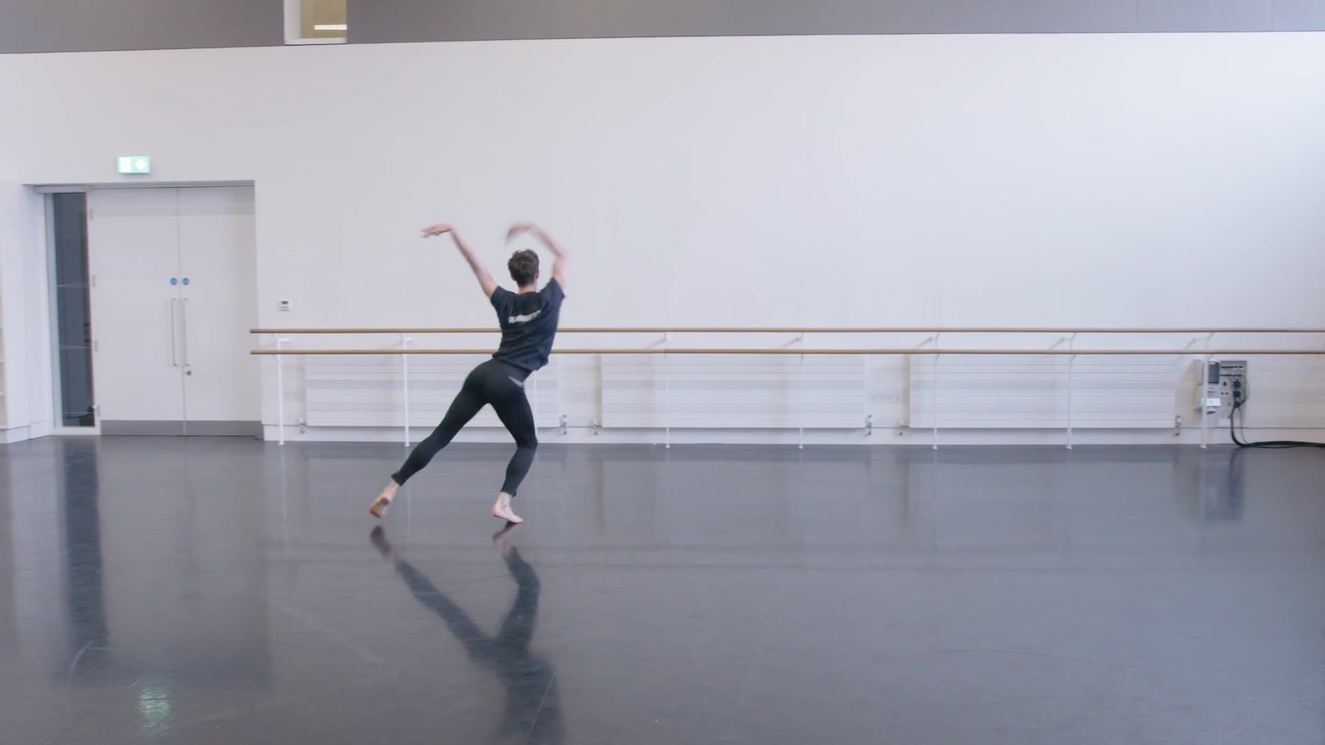 A dancer practicing in an empty dance studio.