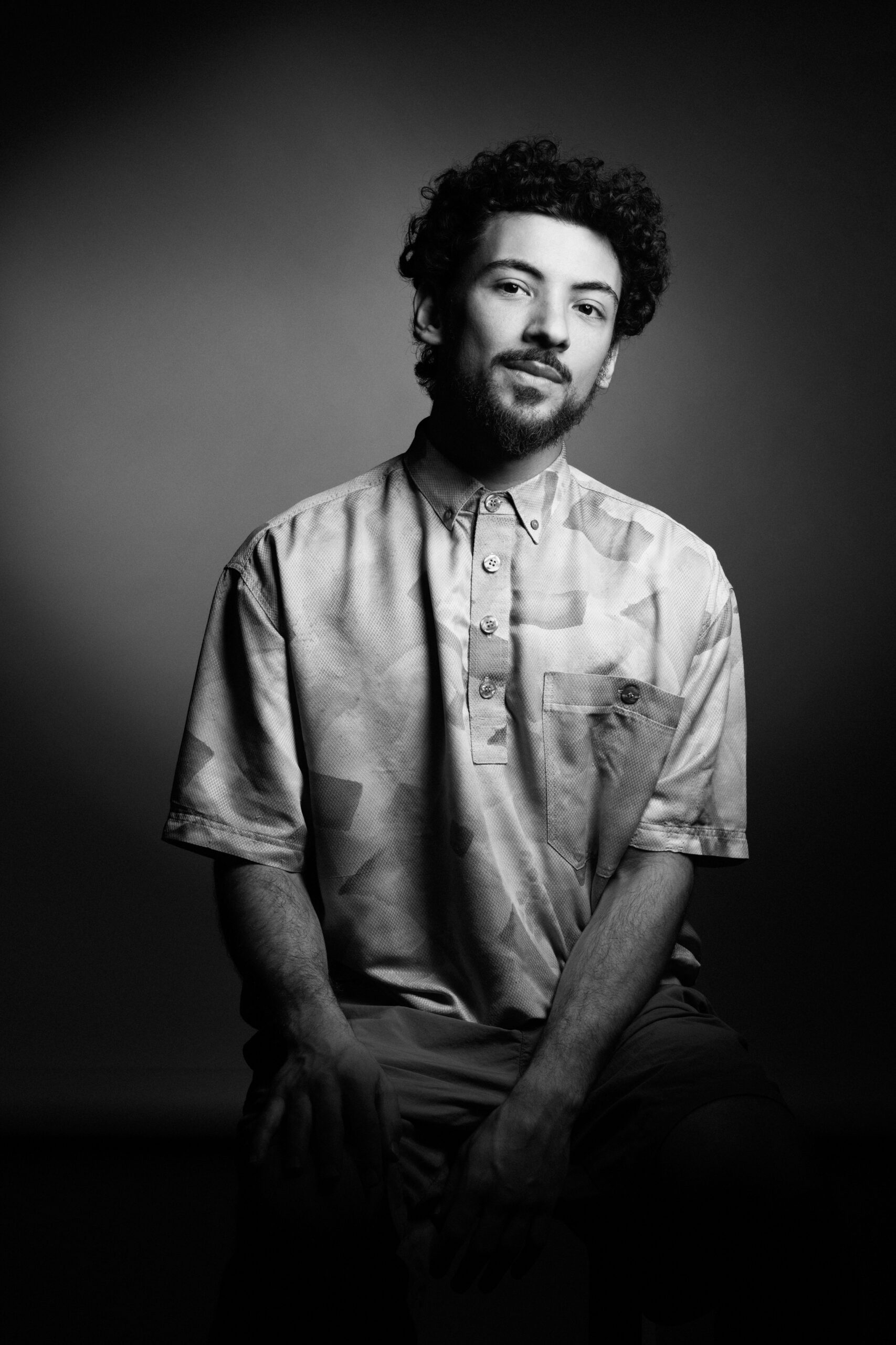 a black and white photo of a man with curly hair.