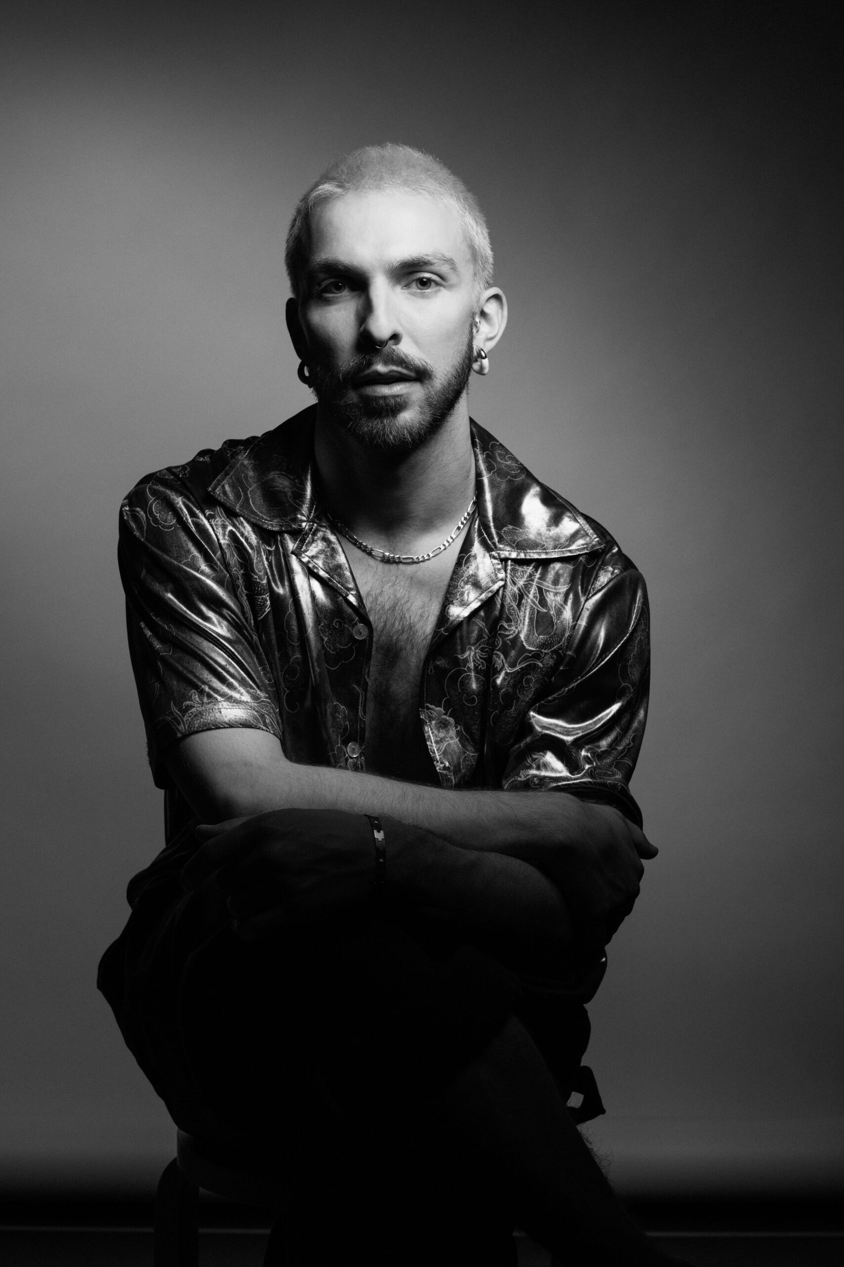 a man in a leather jacket sitting on a chair.