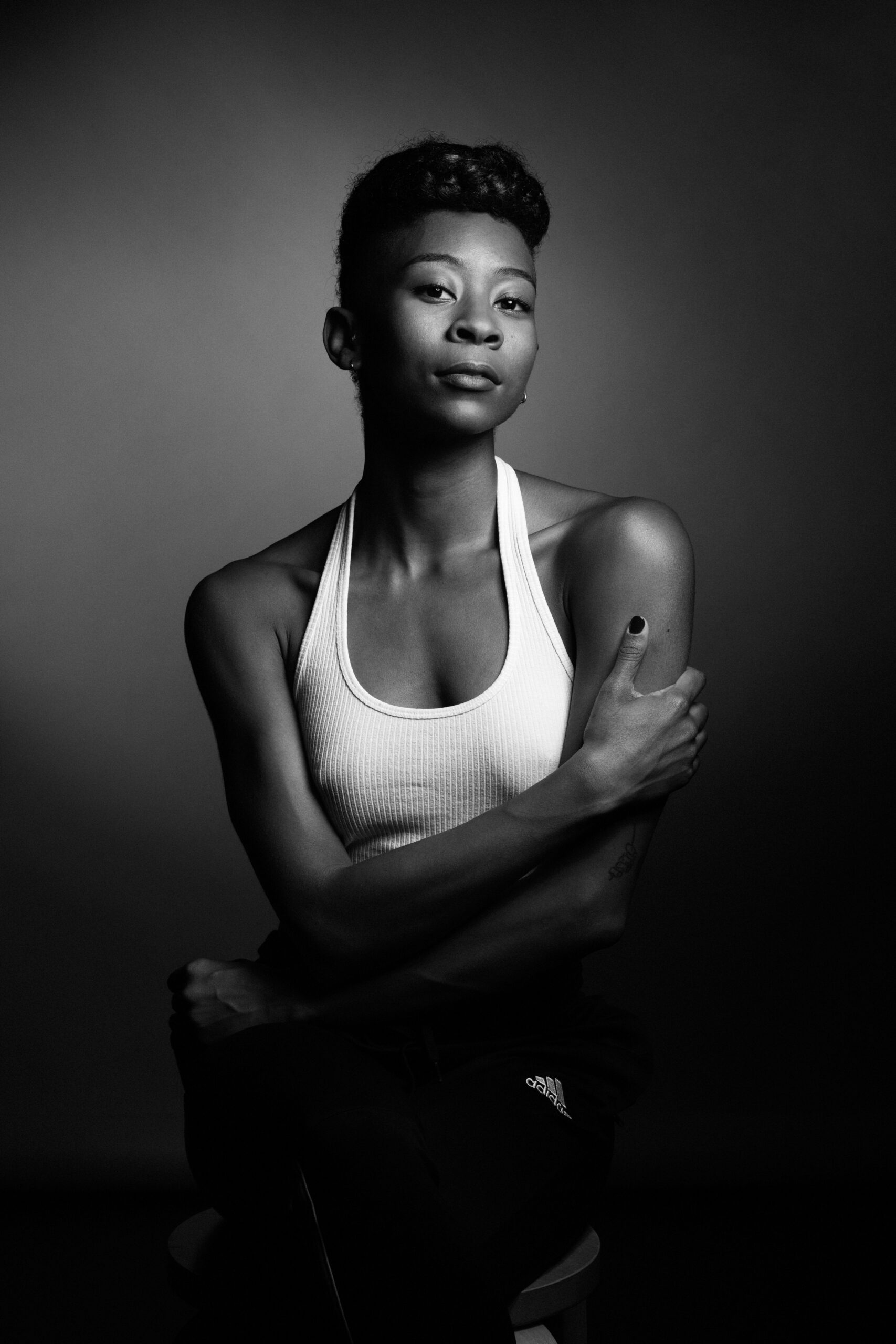 a black and white photo of a woman in a tank top.
