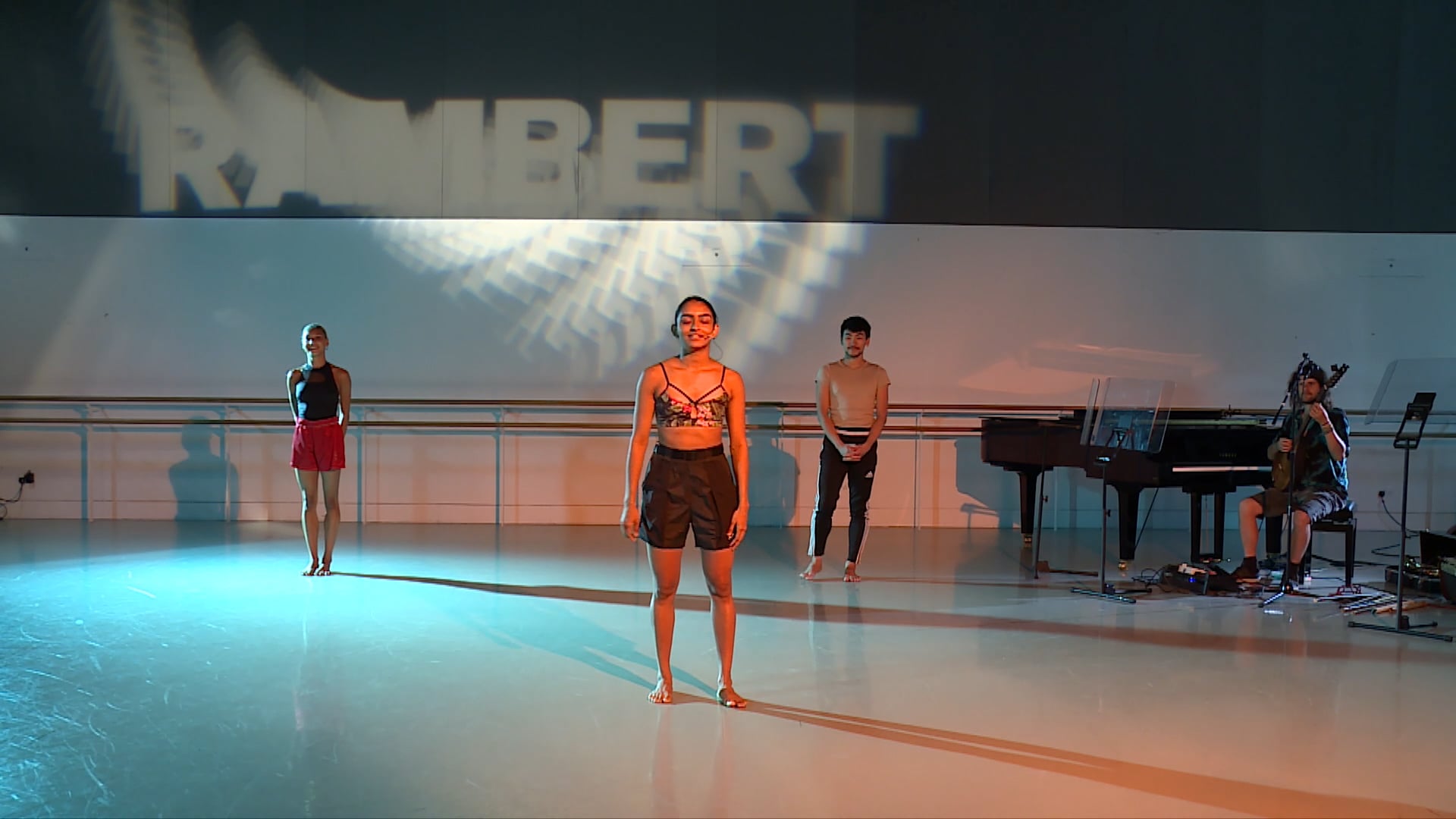 a group of people standing on a stage in front of a piano.