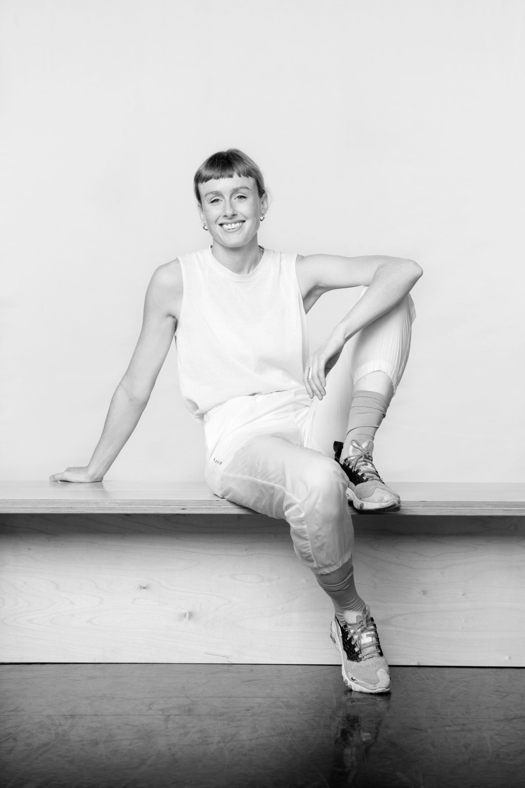 a black and white photo of a man sitting on a bench.