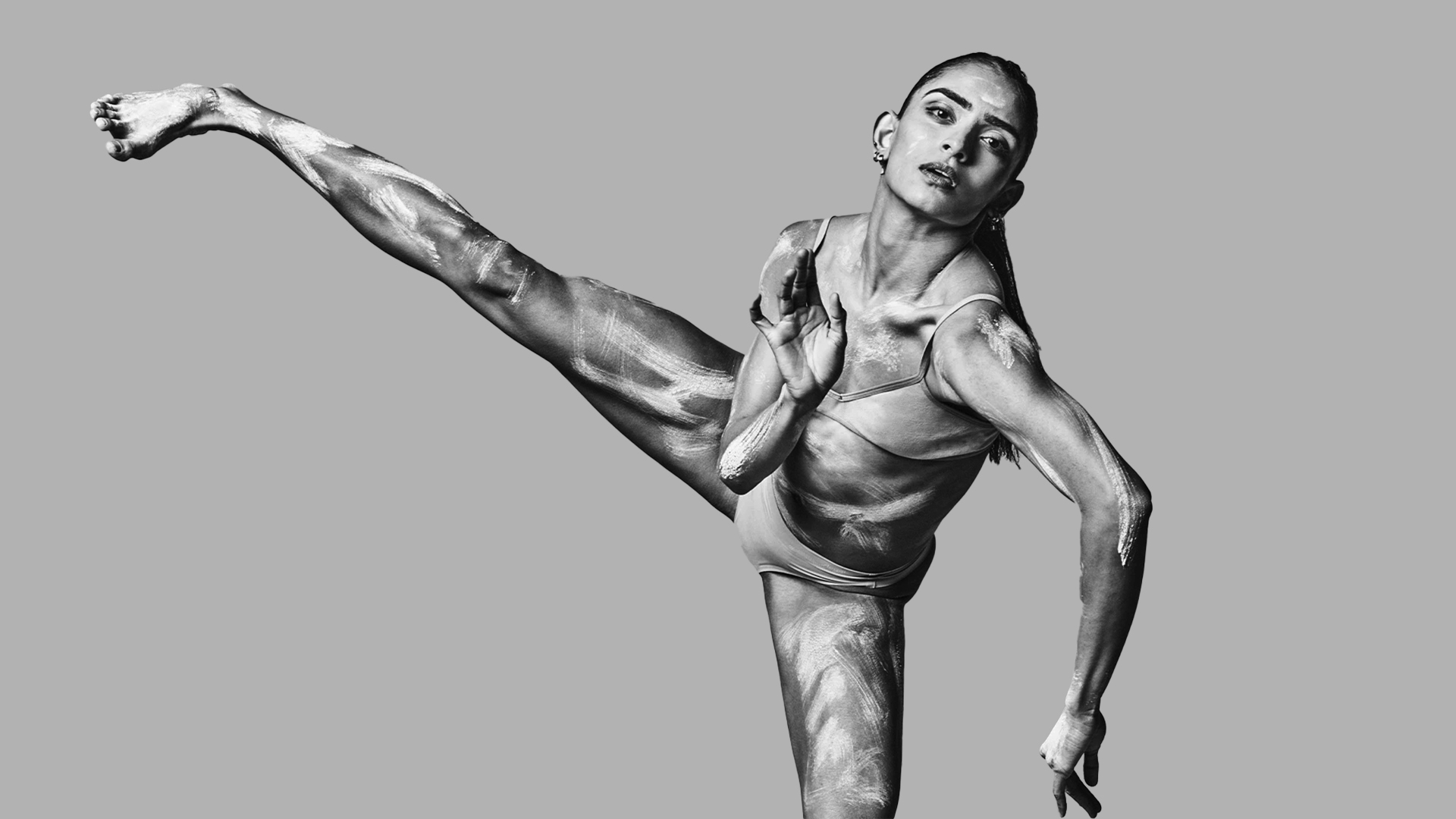 a black and white photo of a man doing a kick.