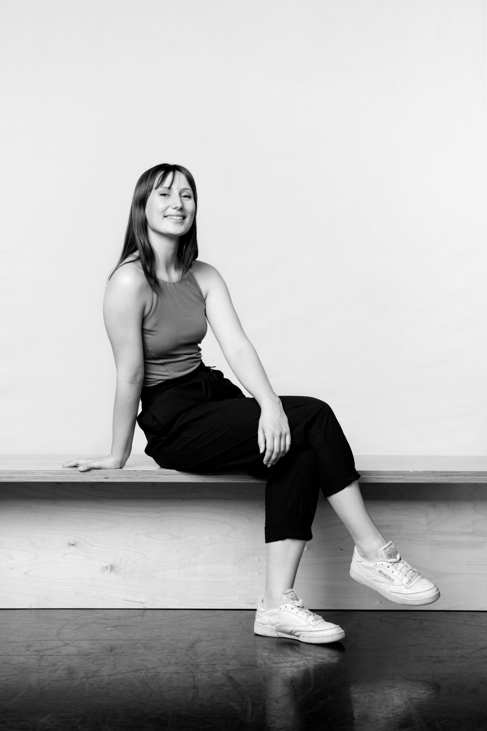 a black and white photo of a woman sitting on a bench.
