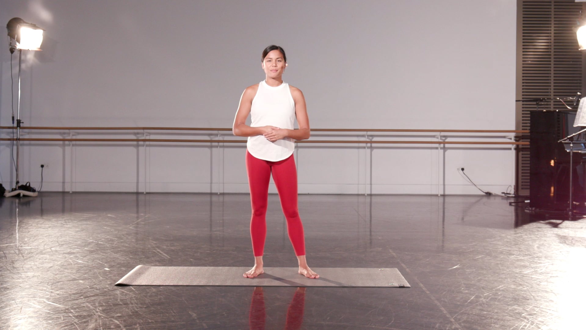 a woman standing on a mat in a dance studio.