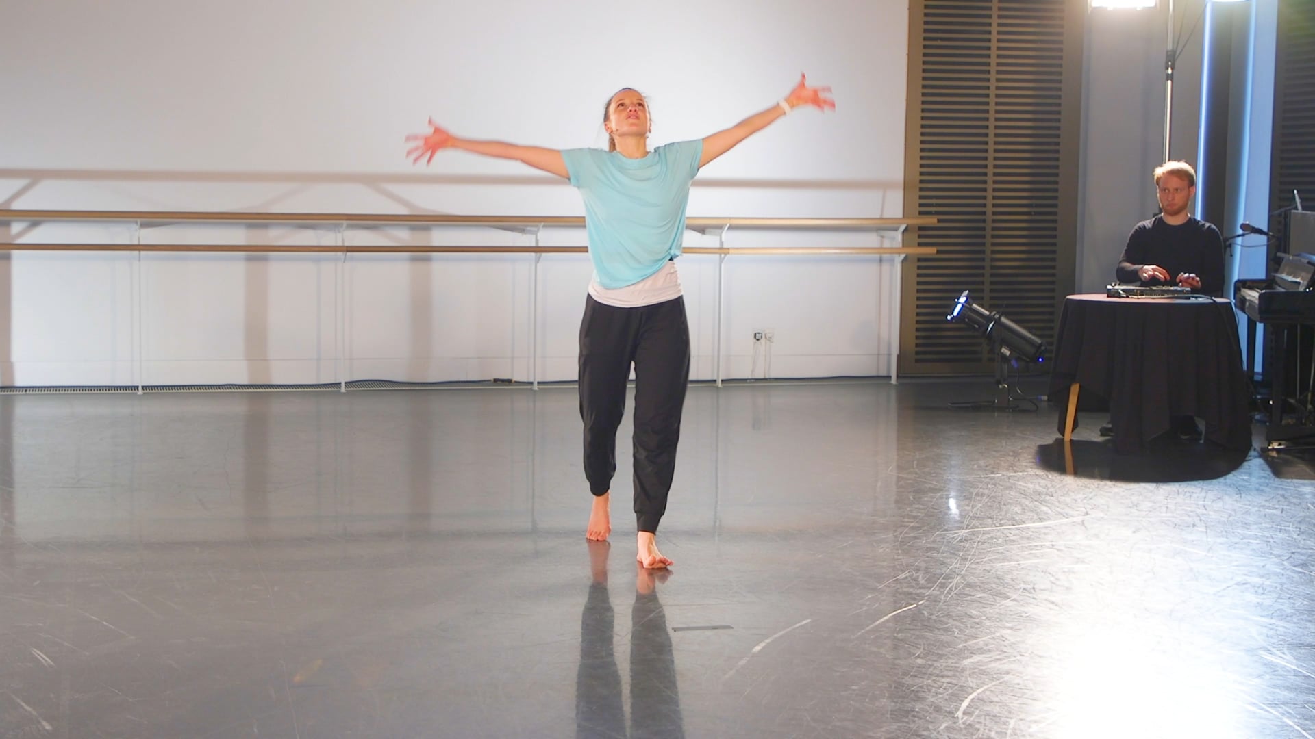 a woman standing on a stage with her arms outstretched.