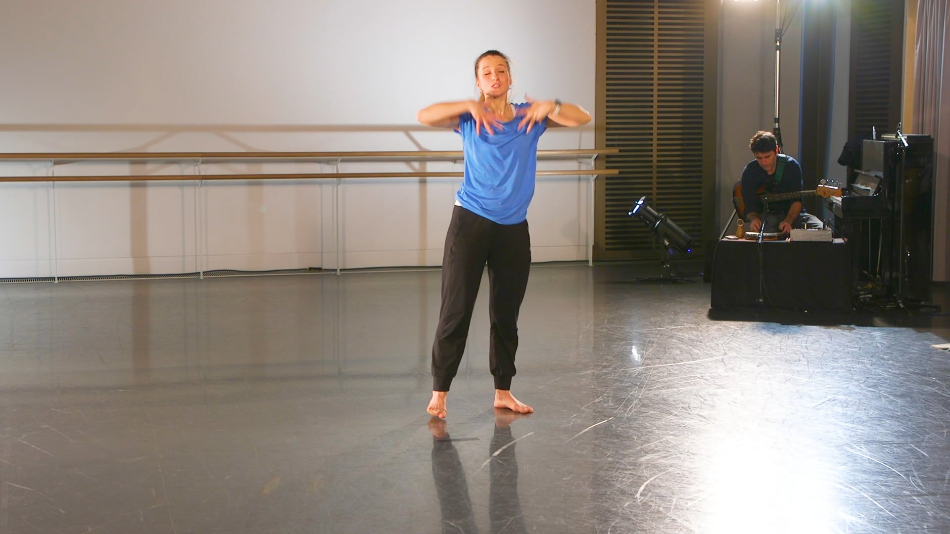 a woman in a blue shirt is dancing.