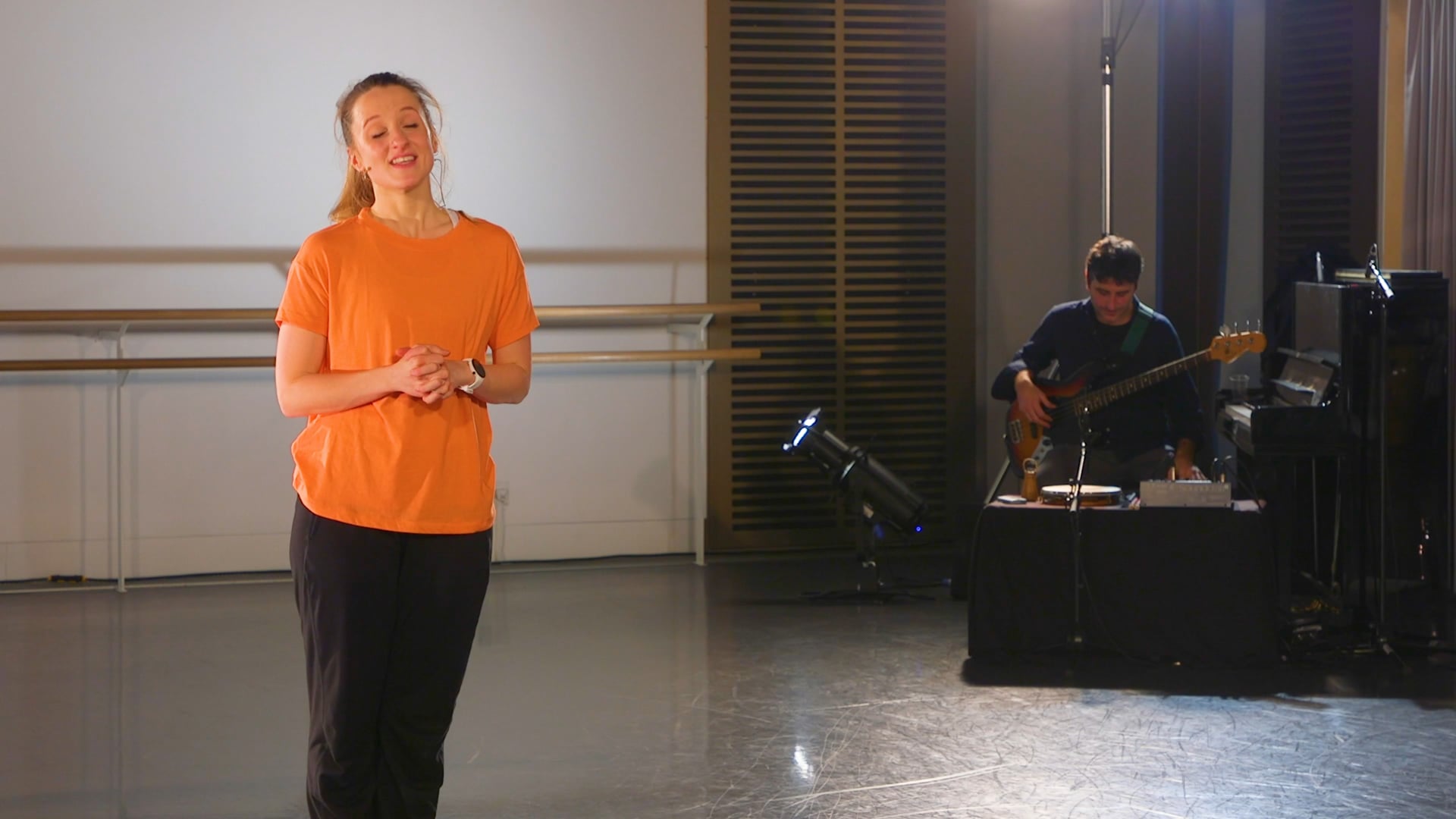 a woman standing in a room with a guitar.