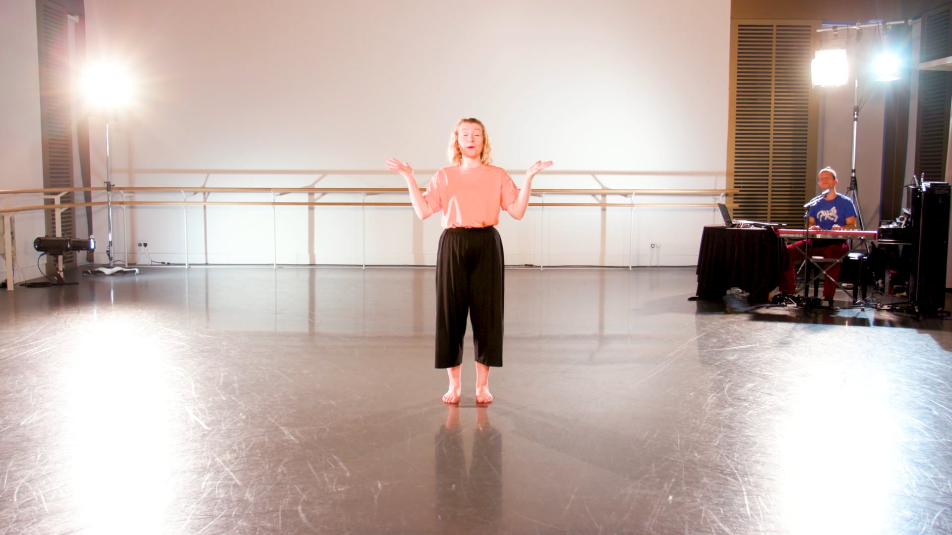 a woman standing on a stage with her hands out.