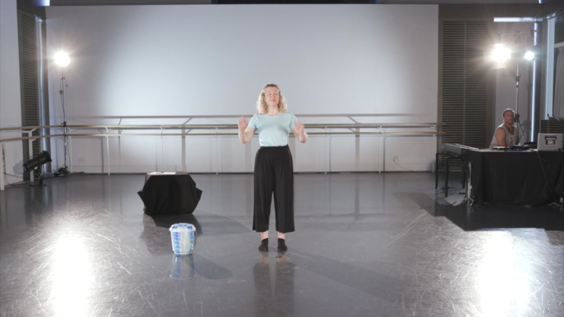 a woman standing on a stage in front of a camera.