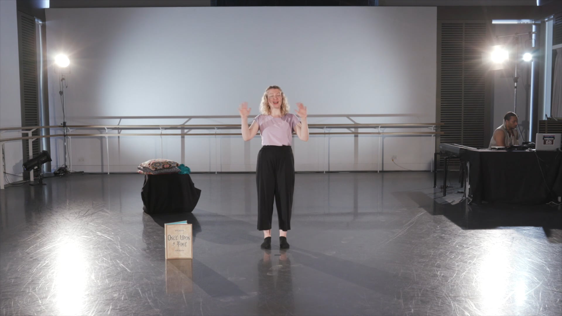 a woman standing on a stage with her hands in the air.