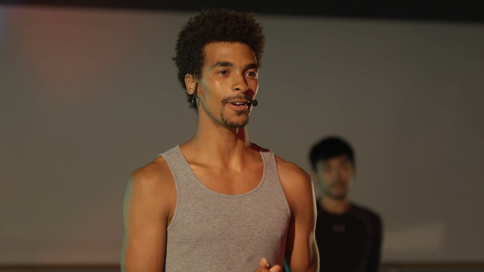 a man standing in front of a projection screen.