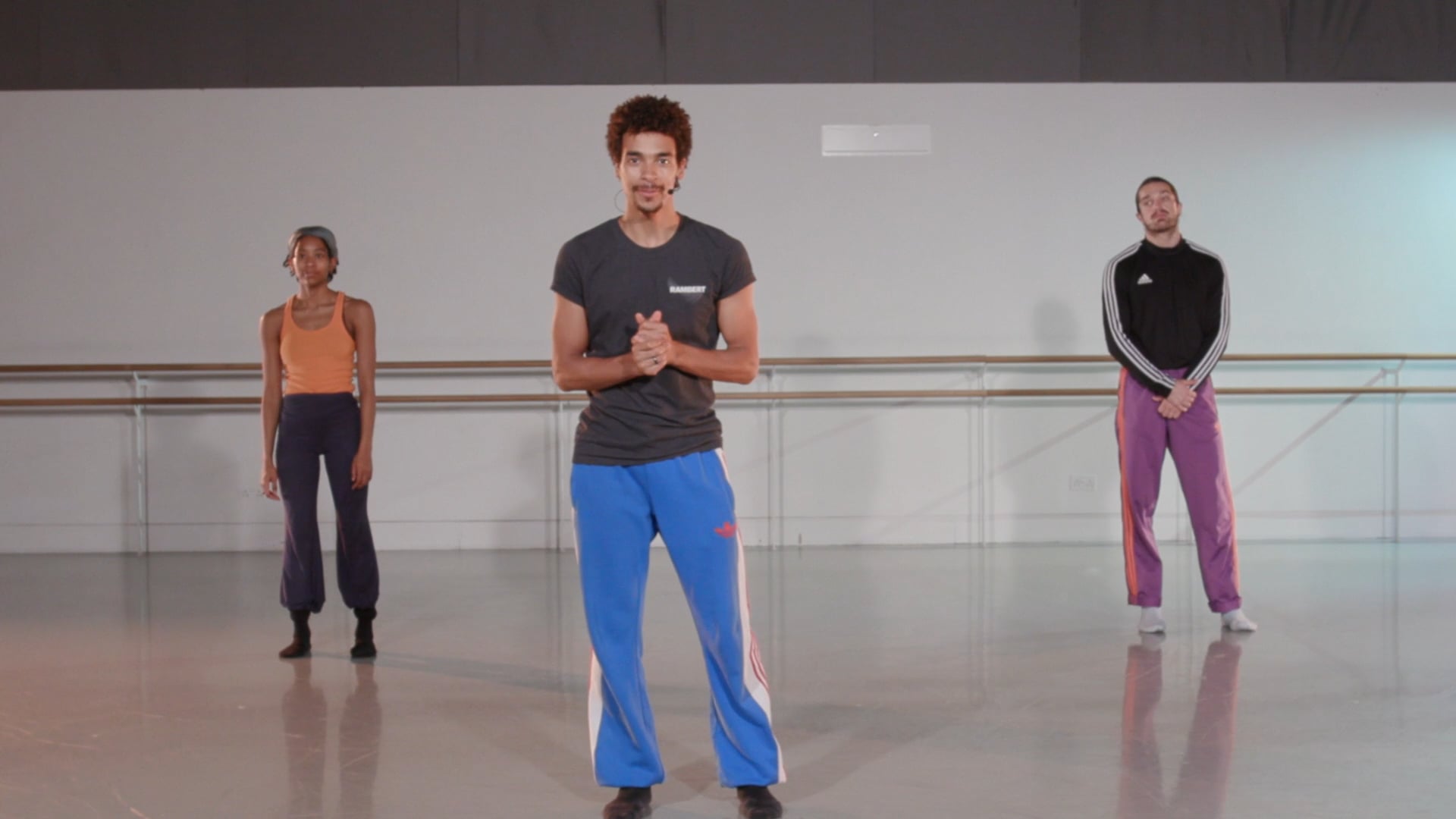 a group of people standing in a dance studio.