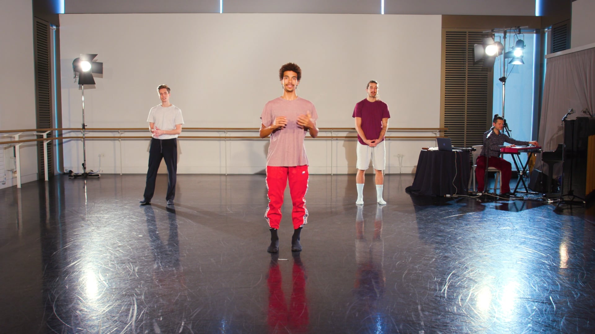 a group of young men standing on top of a dance floor.