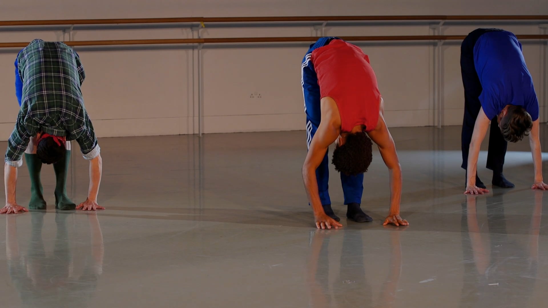 a group of people doing a handstand in a dance studio.