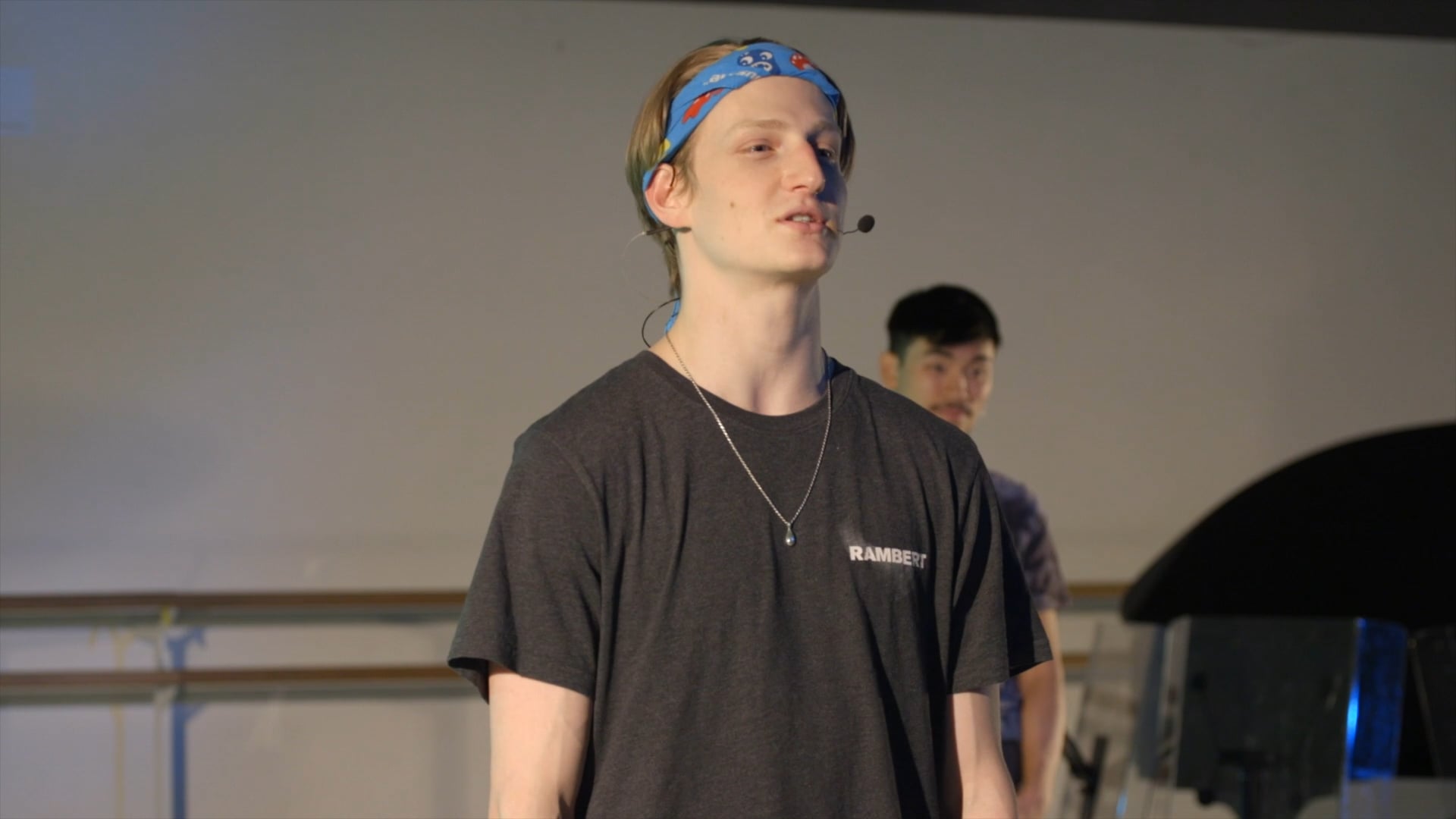 a man with a bandanna on his head standing next to another man.