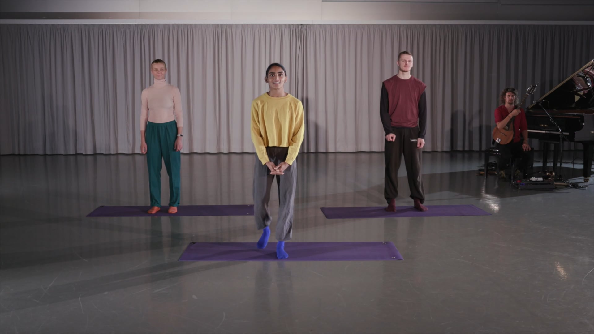 a group of people standing on top of purple mats.