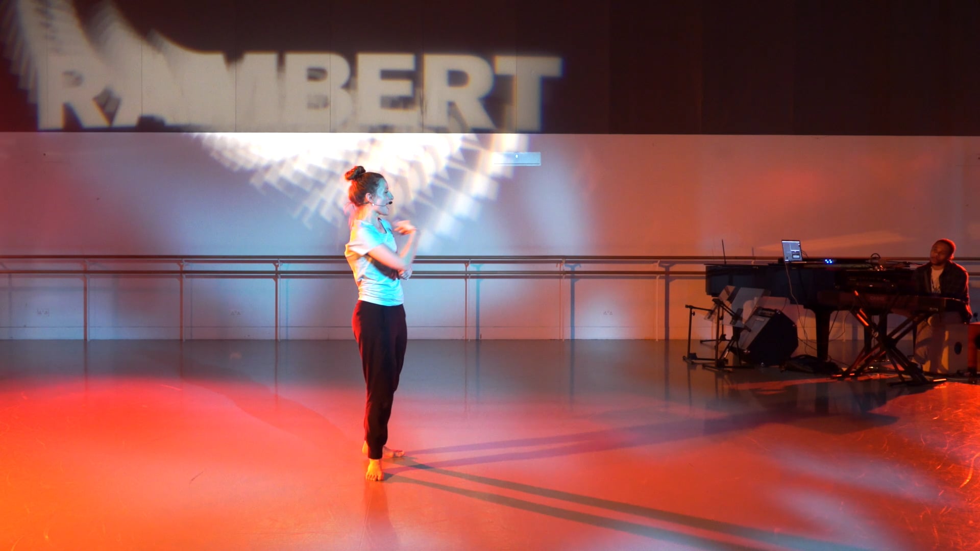 a woman standing on a stage with a microphone.