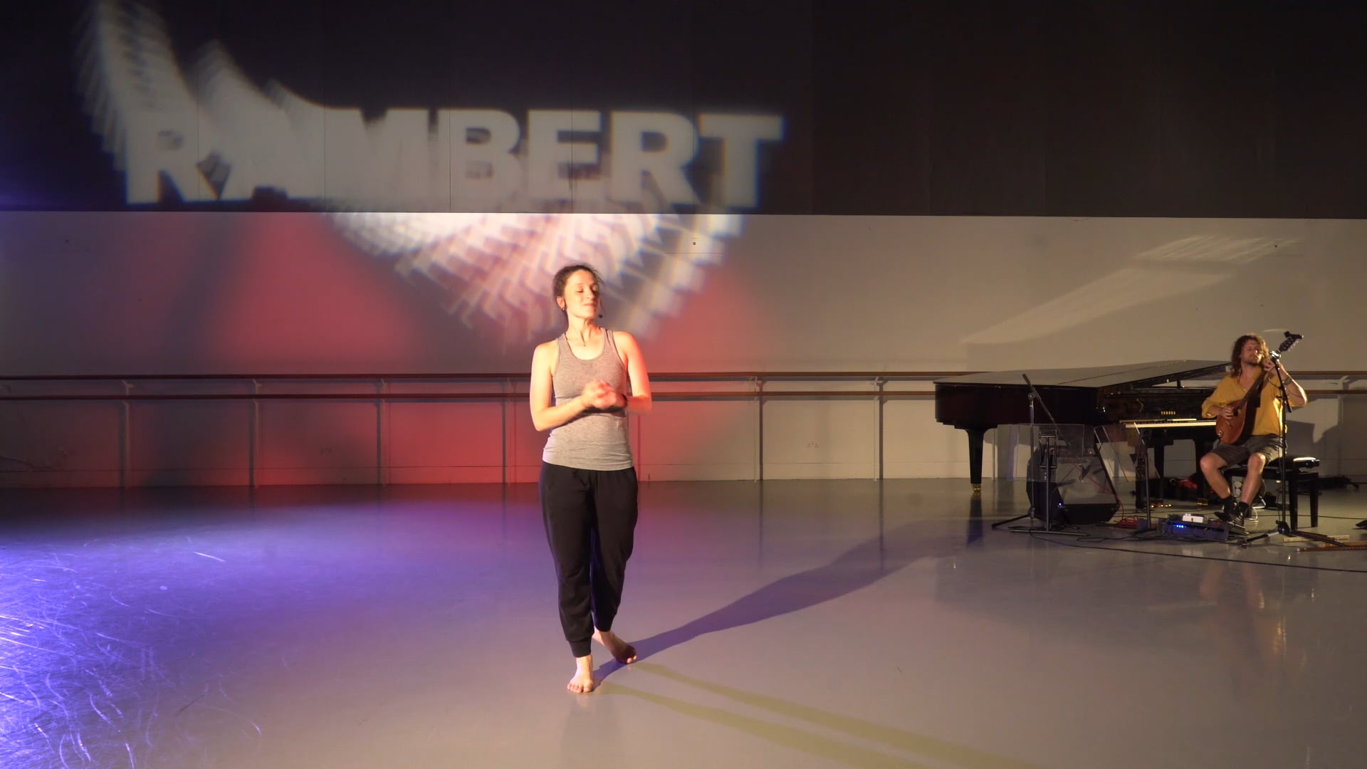 a woman standing on a stage in front of a piano.