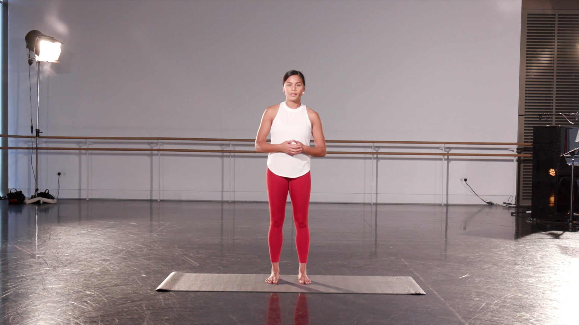 a woman standing on a mat in a dance studio.