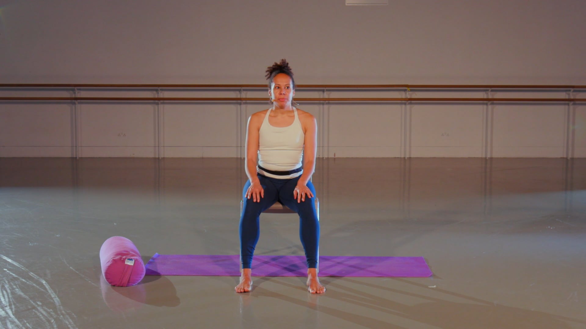 a woman standing on a yoga mat in a gym.