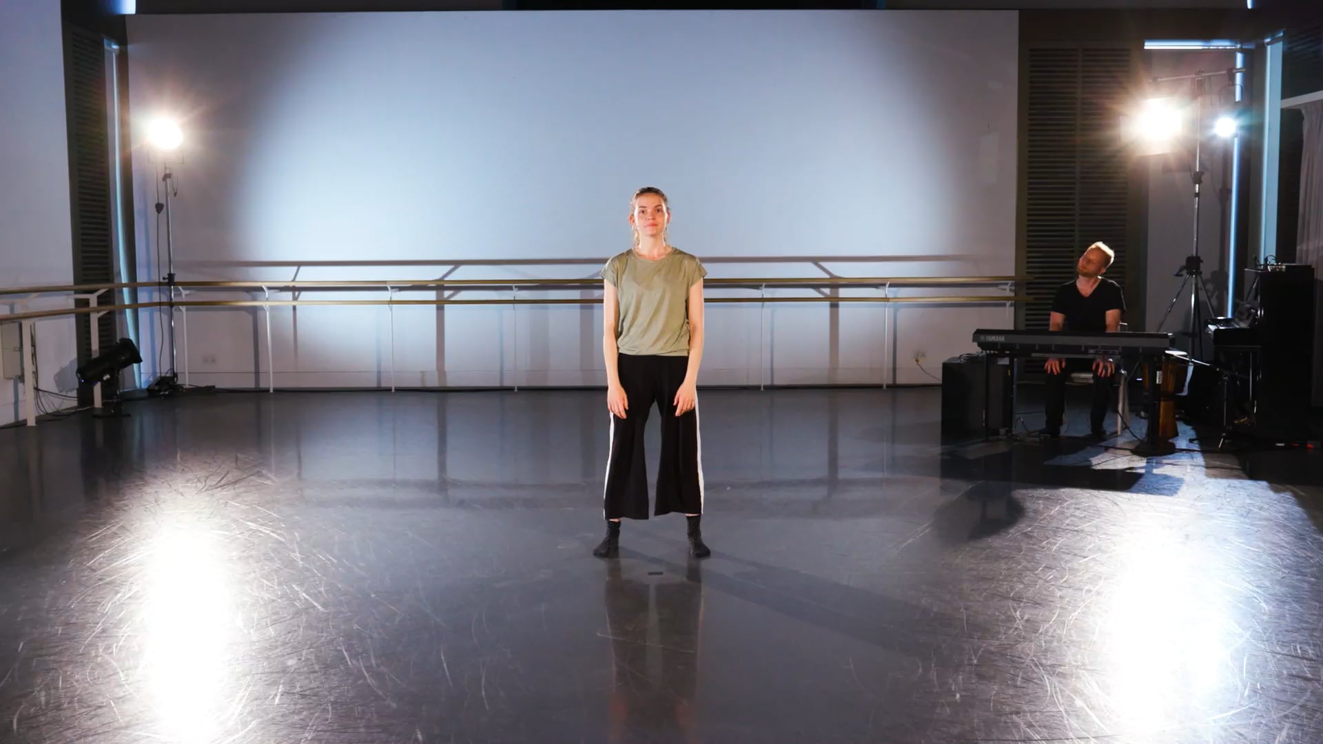 a man standing on a stage in front of a piano.