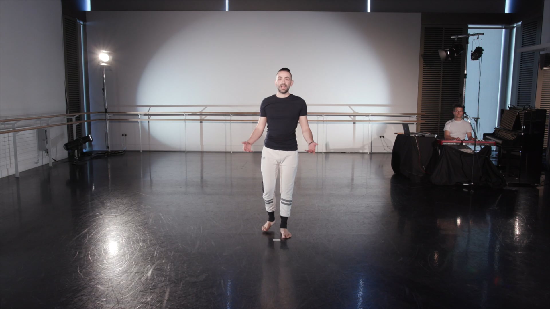 a man in a black shirt and white pants.