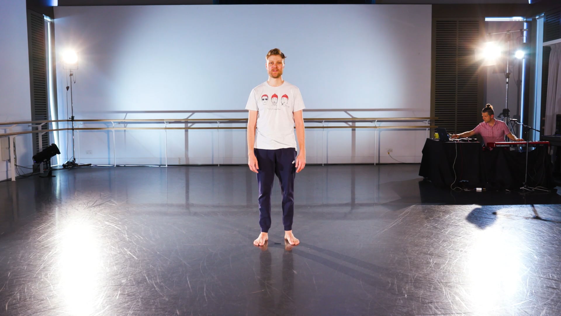 a man standing on a stage in front of a projector screen.