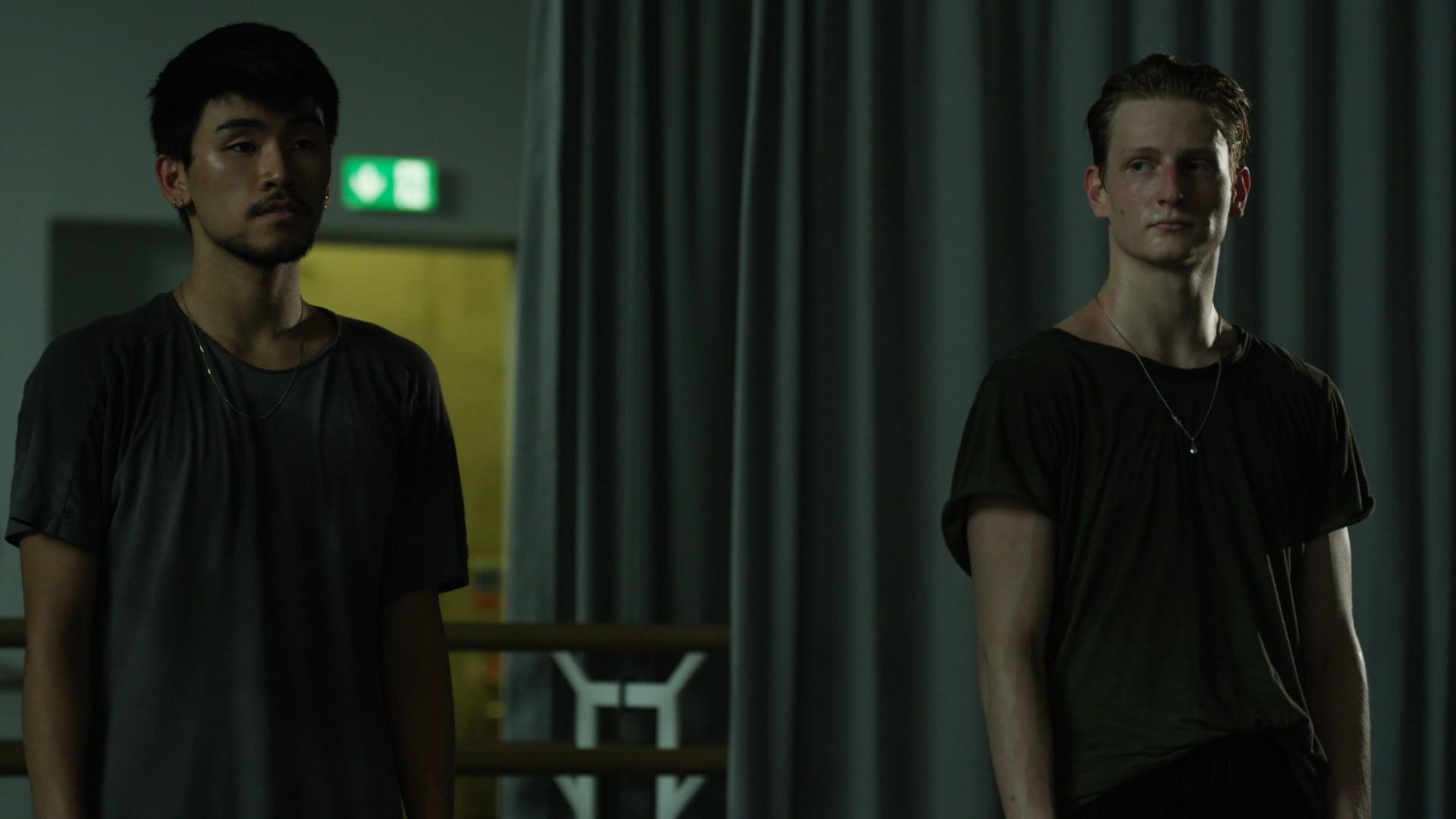 two men standing next to each other in a room.