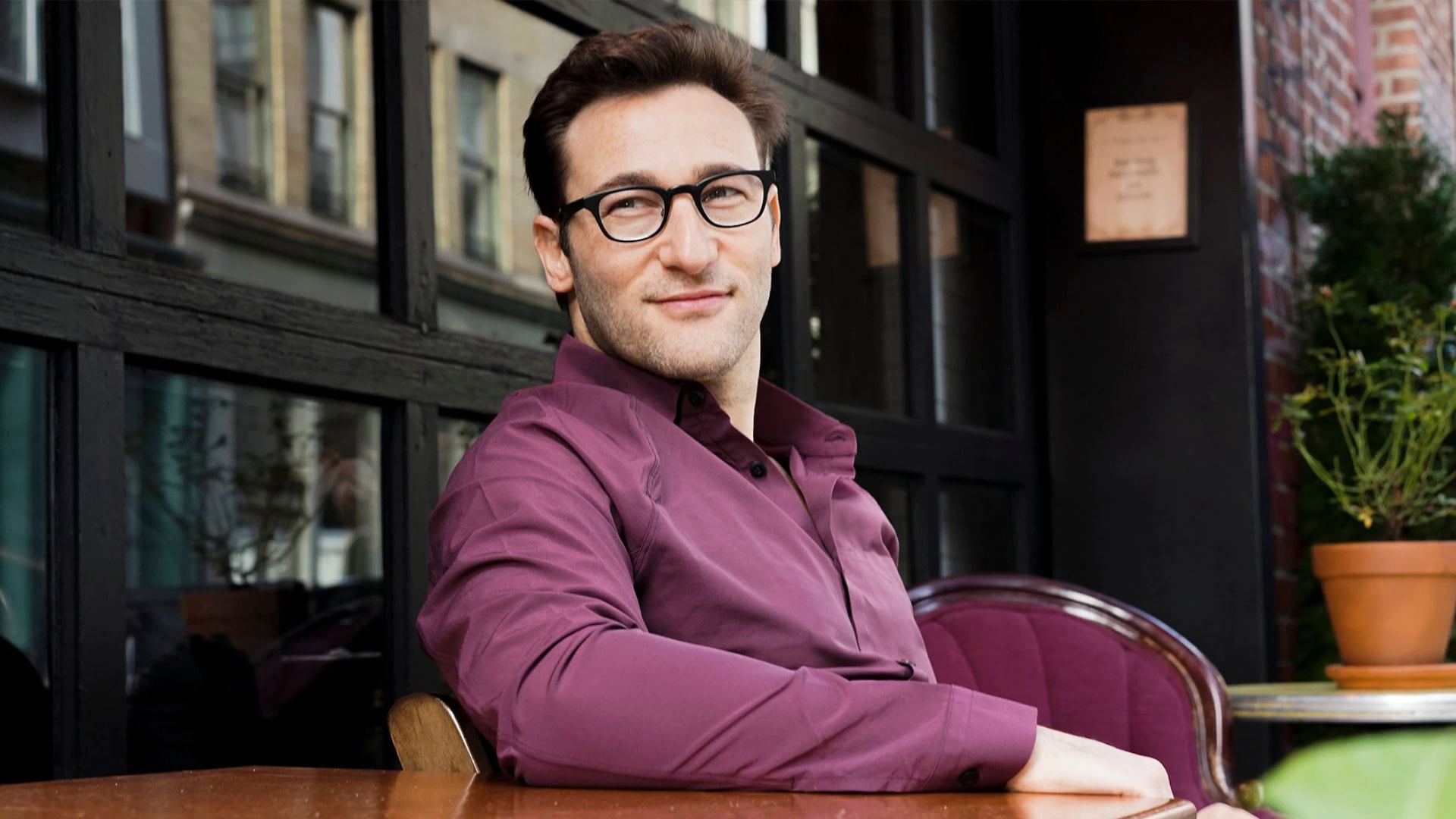 a man wearing glasses sitting at a table.