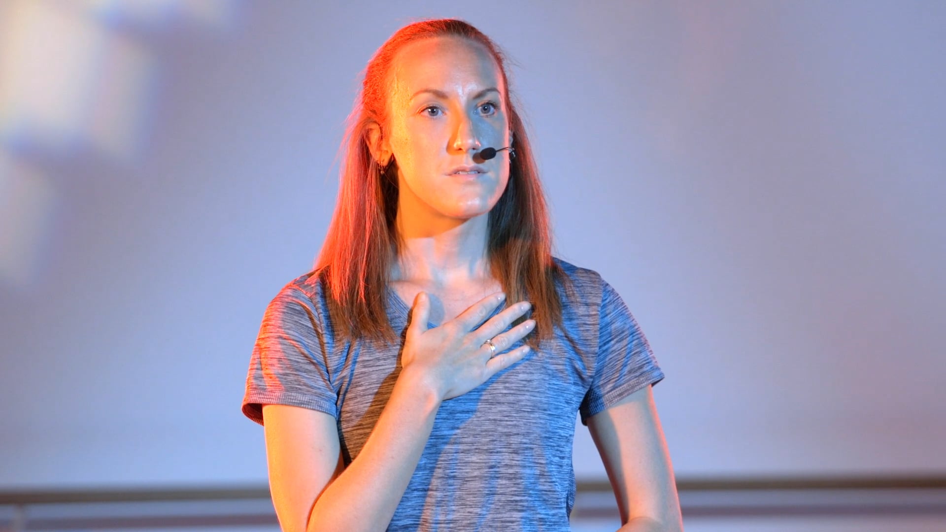 a woman standing in front of a projection screen.