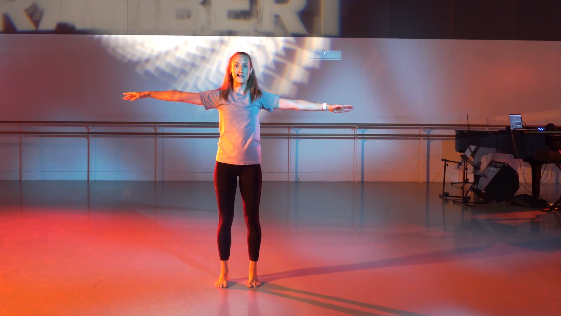 a woman standing on a stage with her arms outstretched.