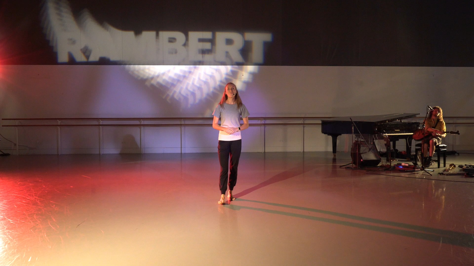 a woman standing on a stage in front of a piano.