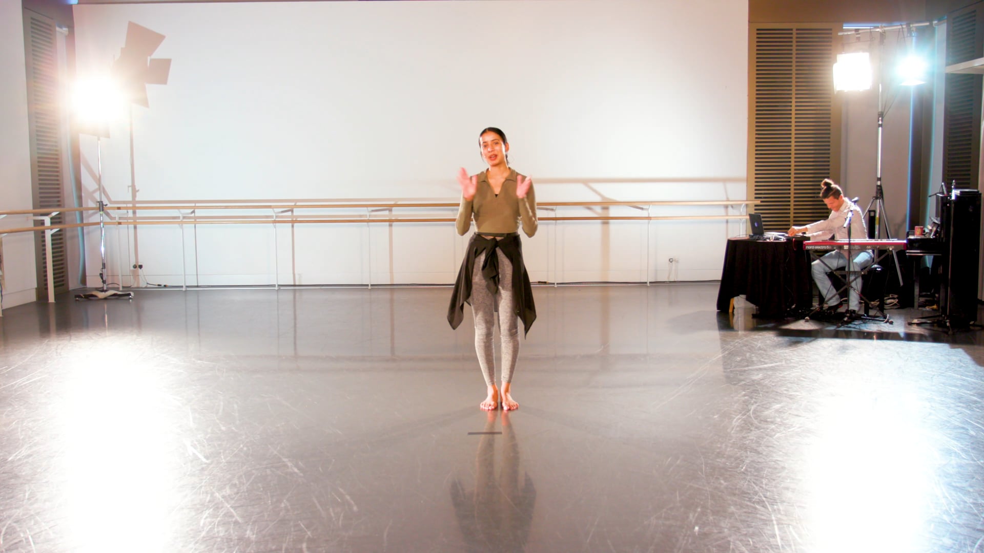 a woman standing on a dance floor in a dance studio.