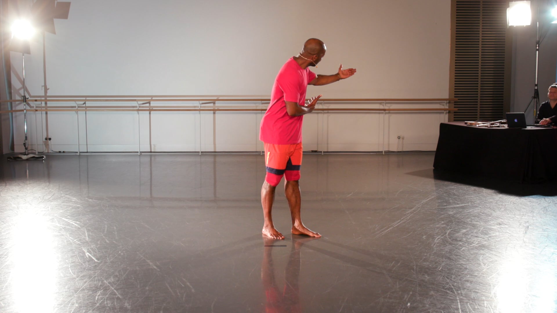 a man in a pink shirt is standing in a room.