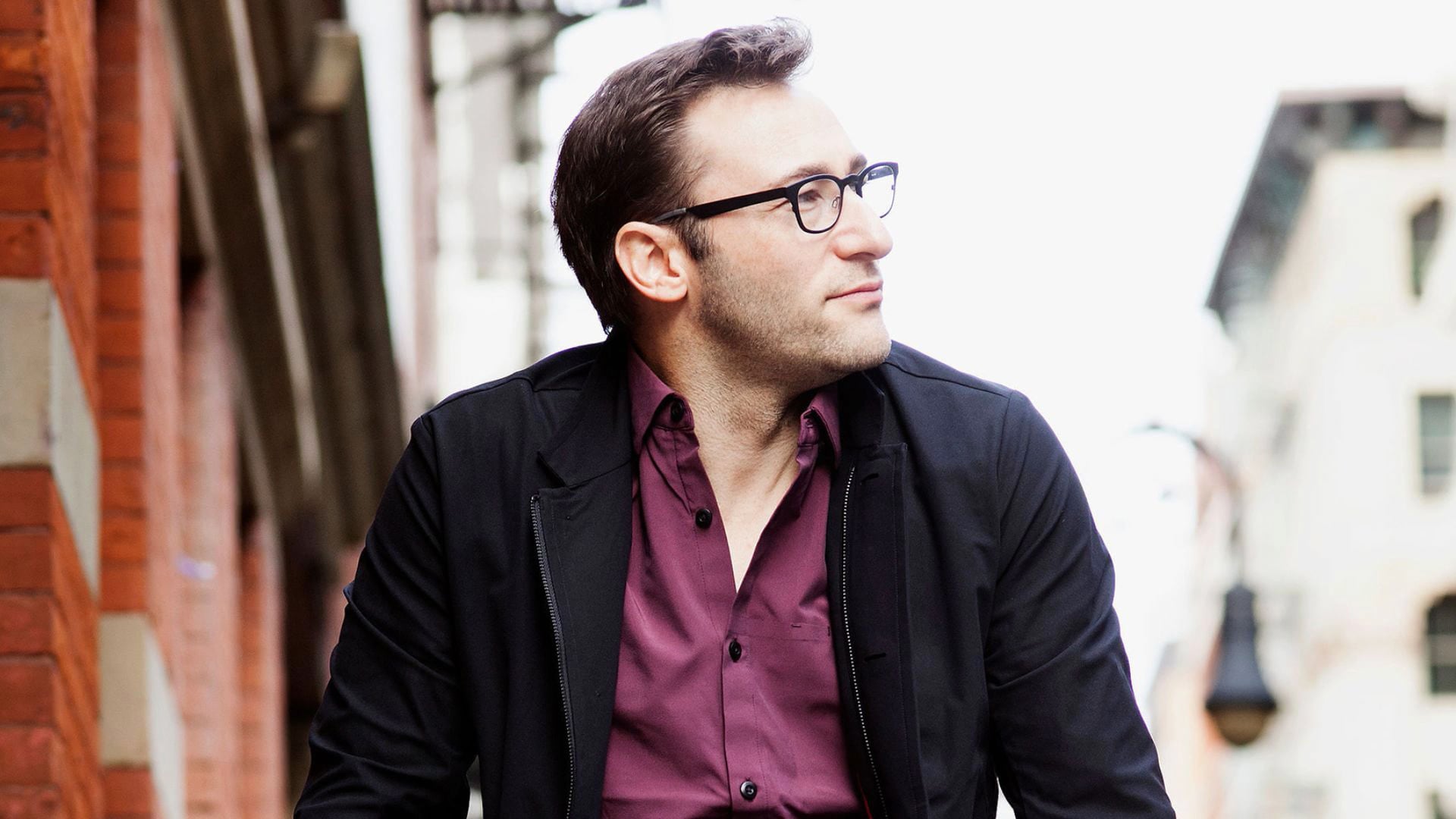 a man wearing glasses and a purple shirt.