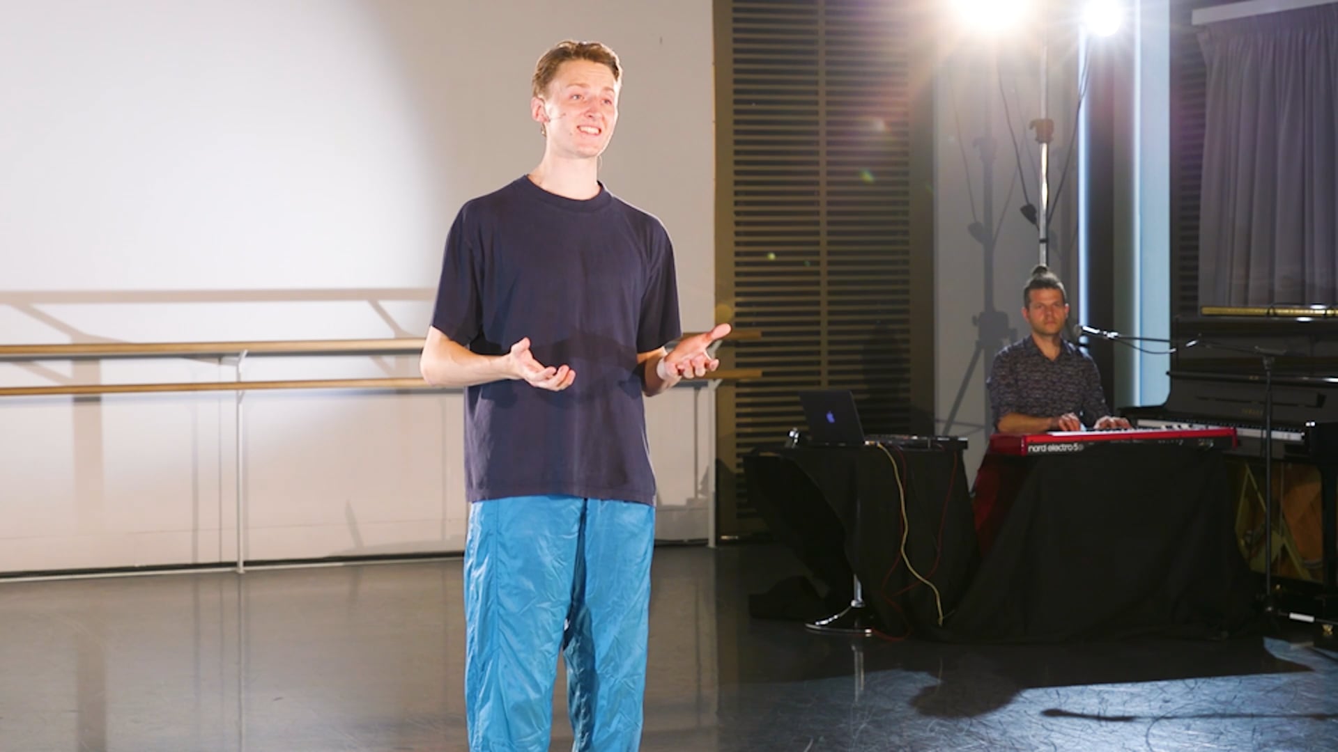 a man standing in front of a microphone in a room.