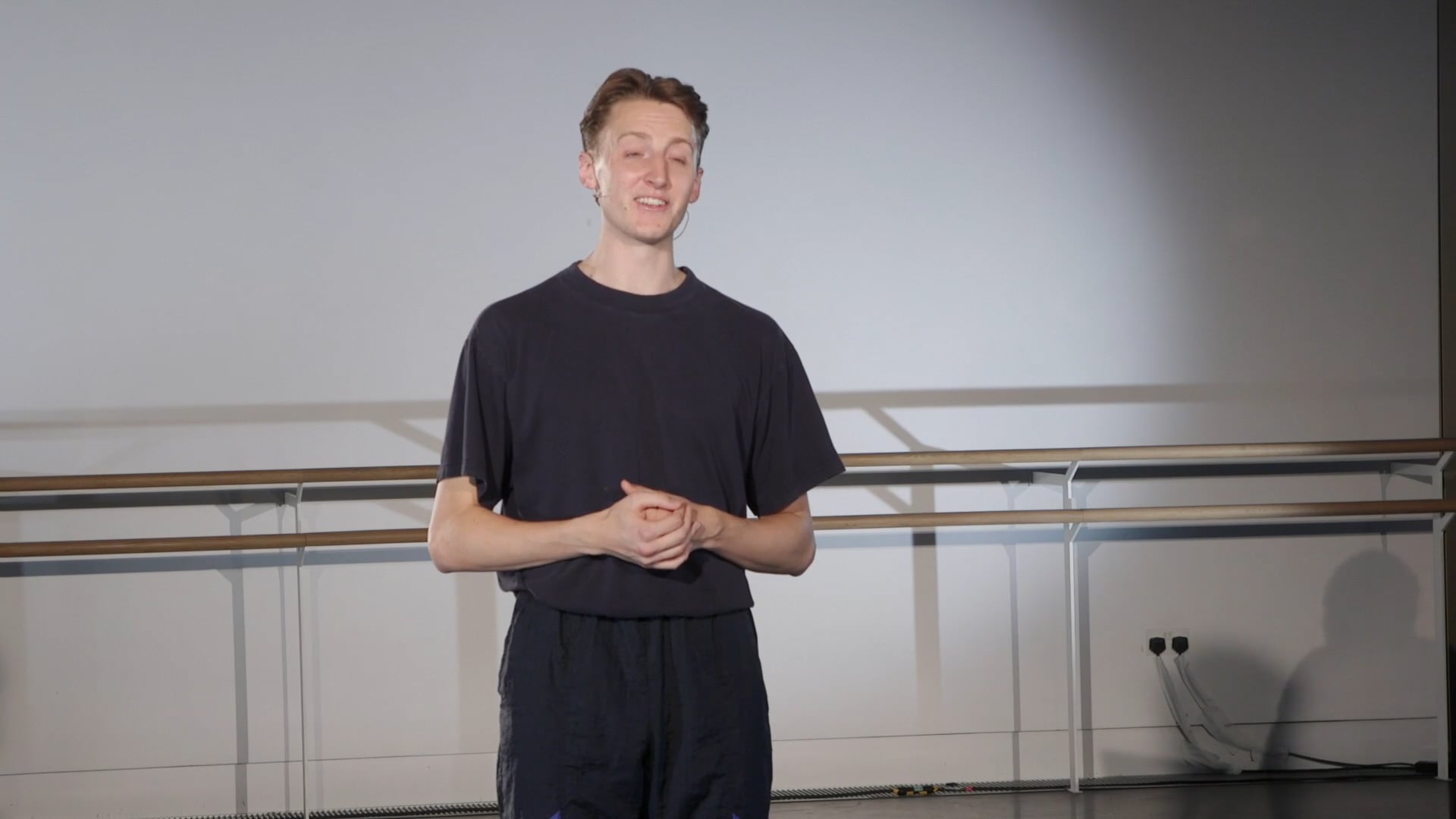 a man standing in front of a projection screen.