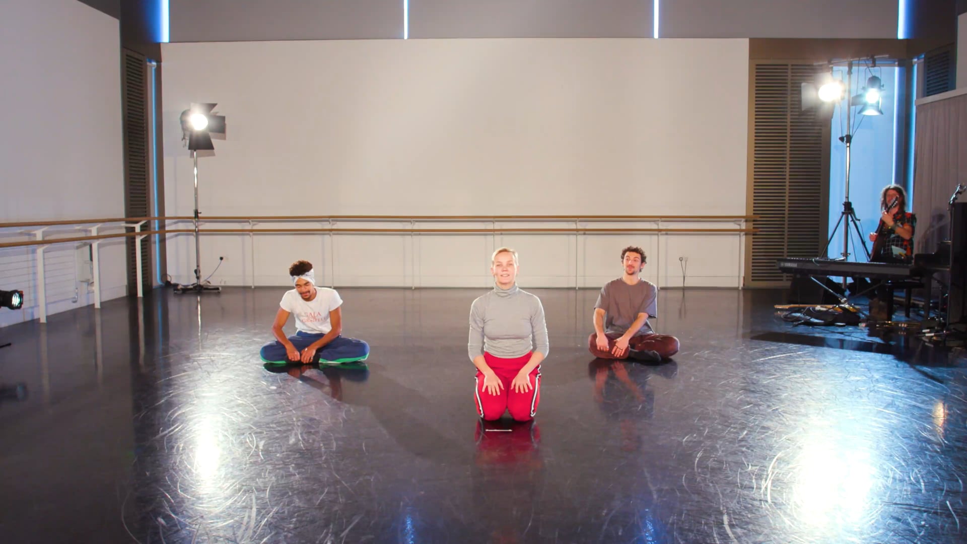 a group of people sitting on top of a black floor.