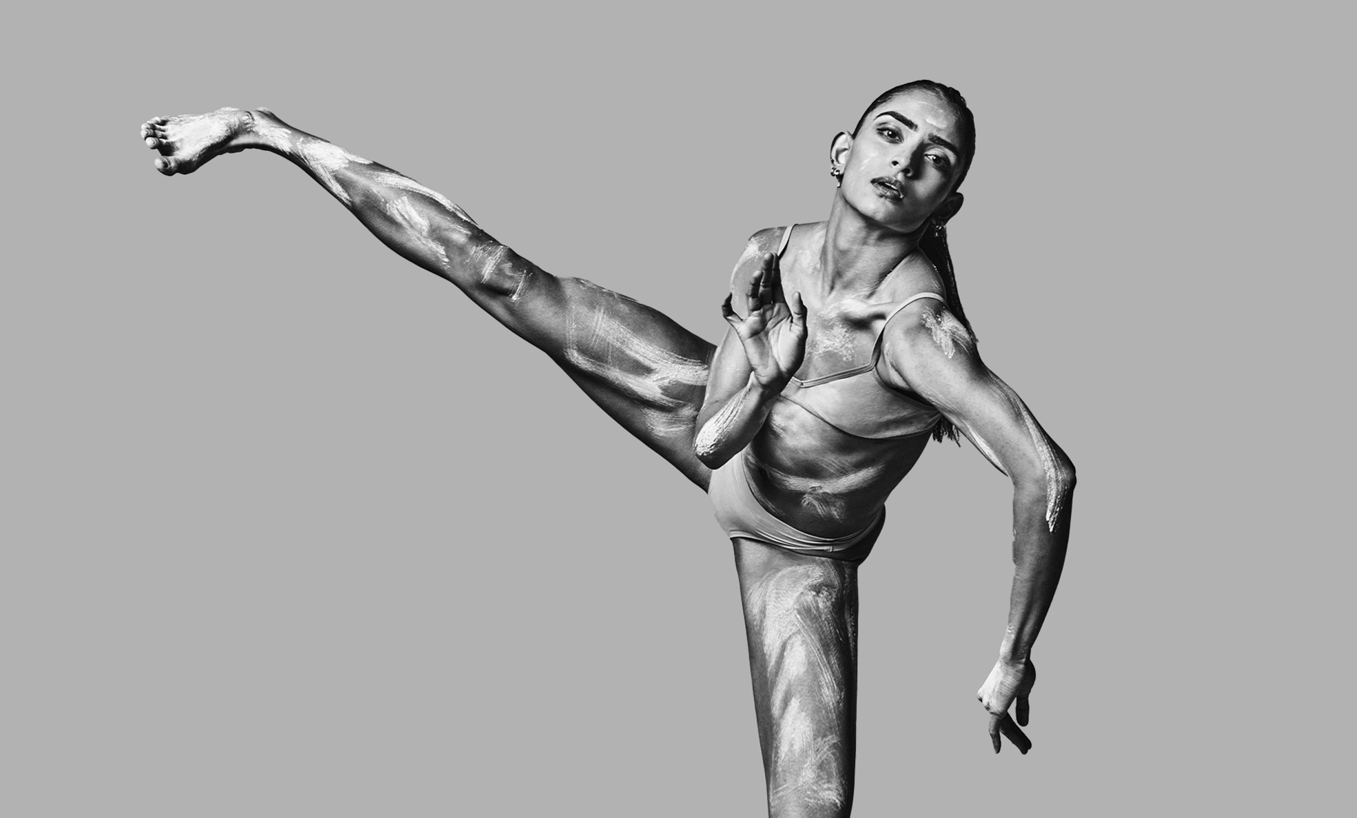 a black and white photo of a man doing a kick.