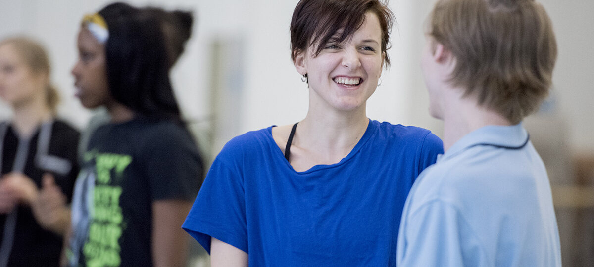 A woman in a blue shirt smiling.